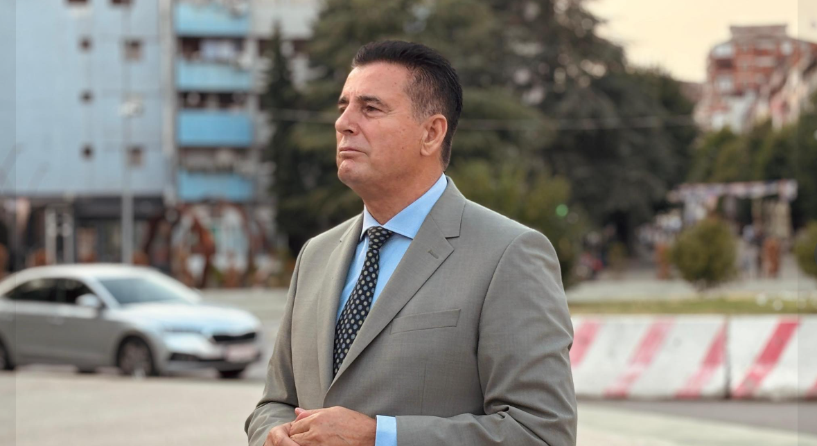 Agim Bahtiri mban fotografinë e Albin Kurtit gjatë tubimit të VV së në Mitrovicë